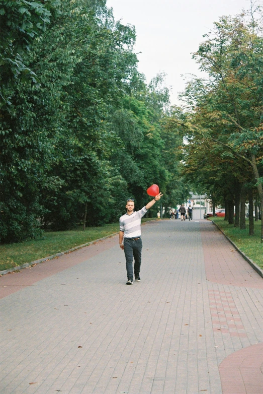 a man on a street throwing soing up into the air