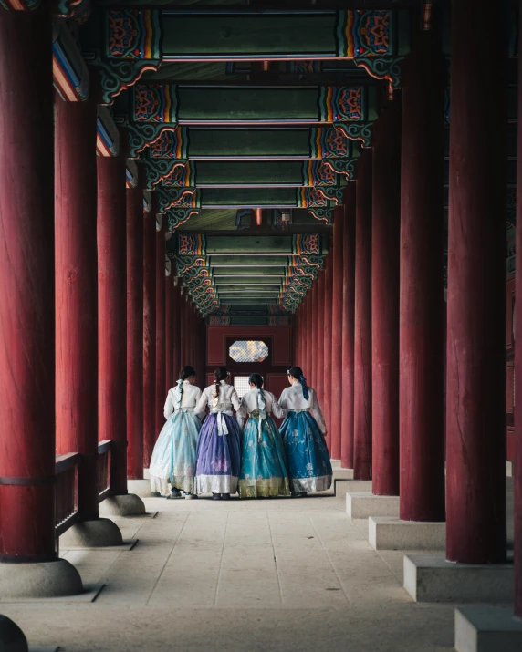 a group of women in colorful clothing walking down a street