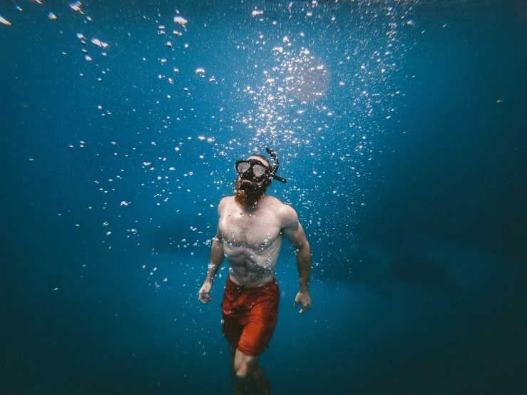 a person standing under the water with diving equipment