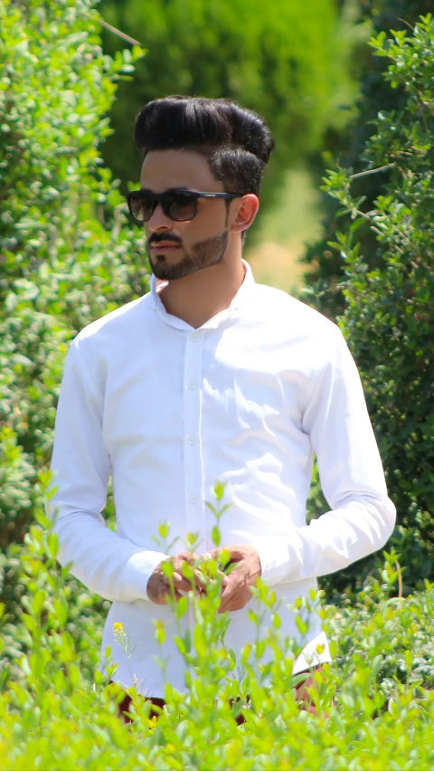 a man in white holding some plants