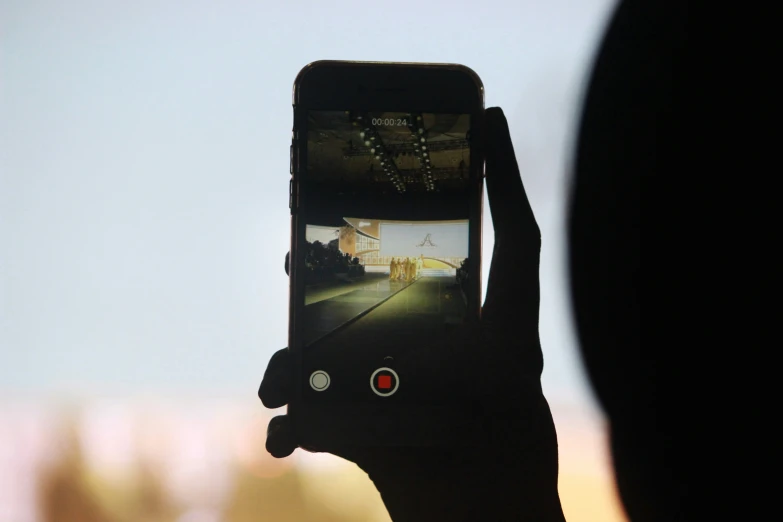 a hand holding a phone with an image of a city