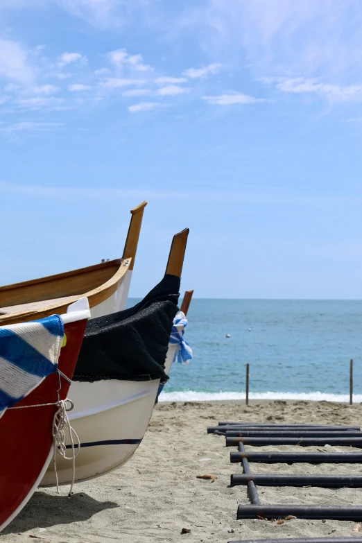 two boat are sitting on the sand of the beach