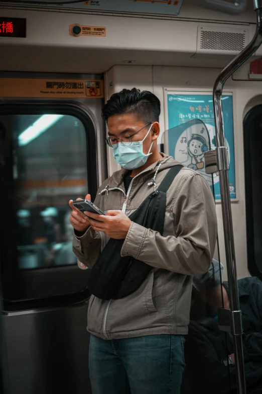 a man using a smartphone while wearing a face mask