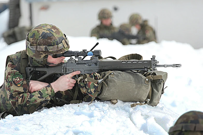 a man sitting in the snow with a gun