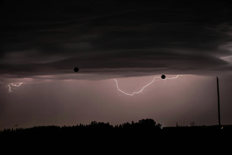 some lightning bolts strike across a dark sky