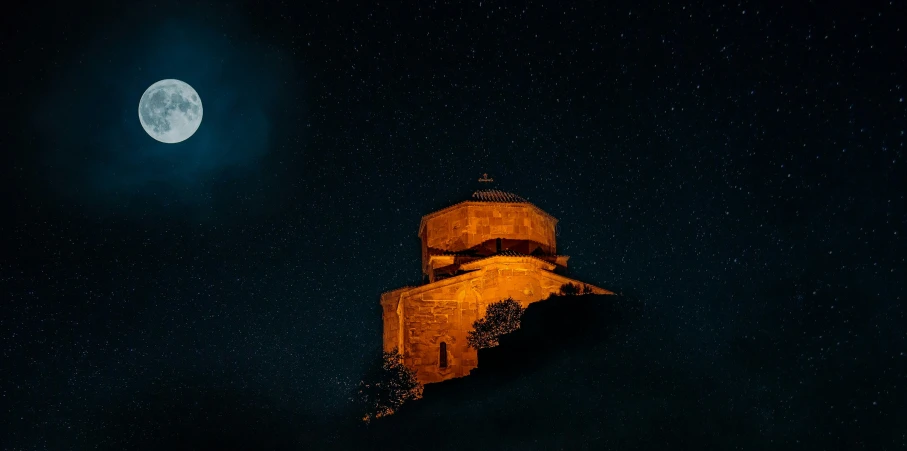 the moon is behind a church in the night