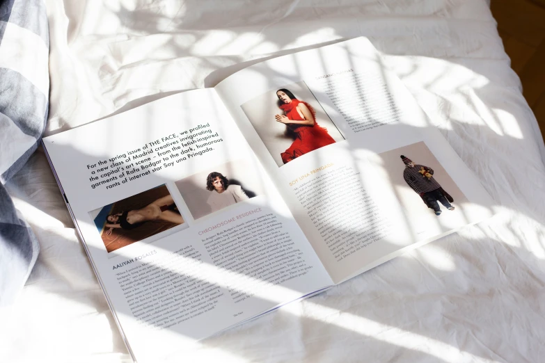 a woman is laying on the bed with an open book