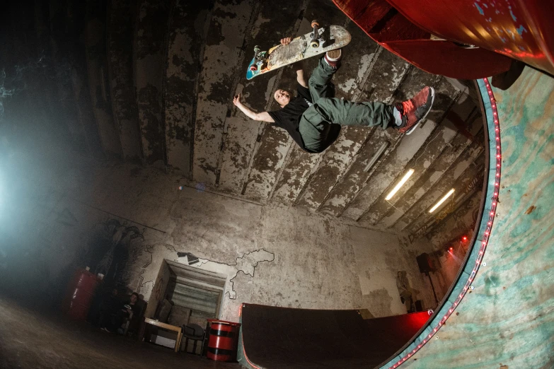 skateboarder performing trick on ramp in dark concrete