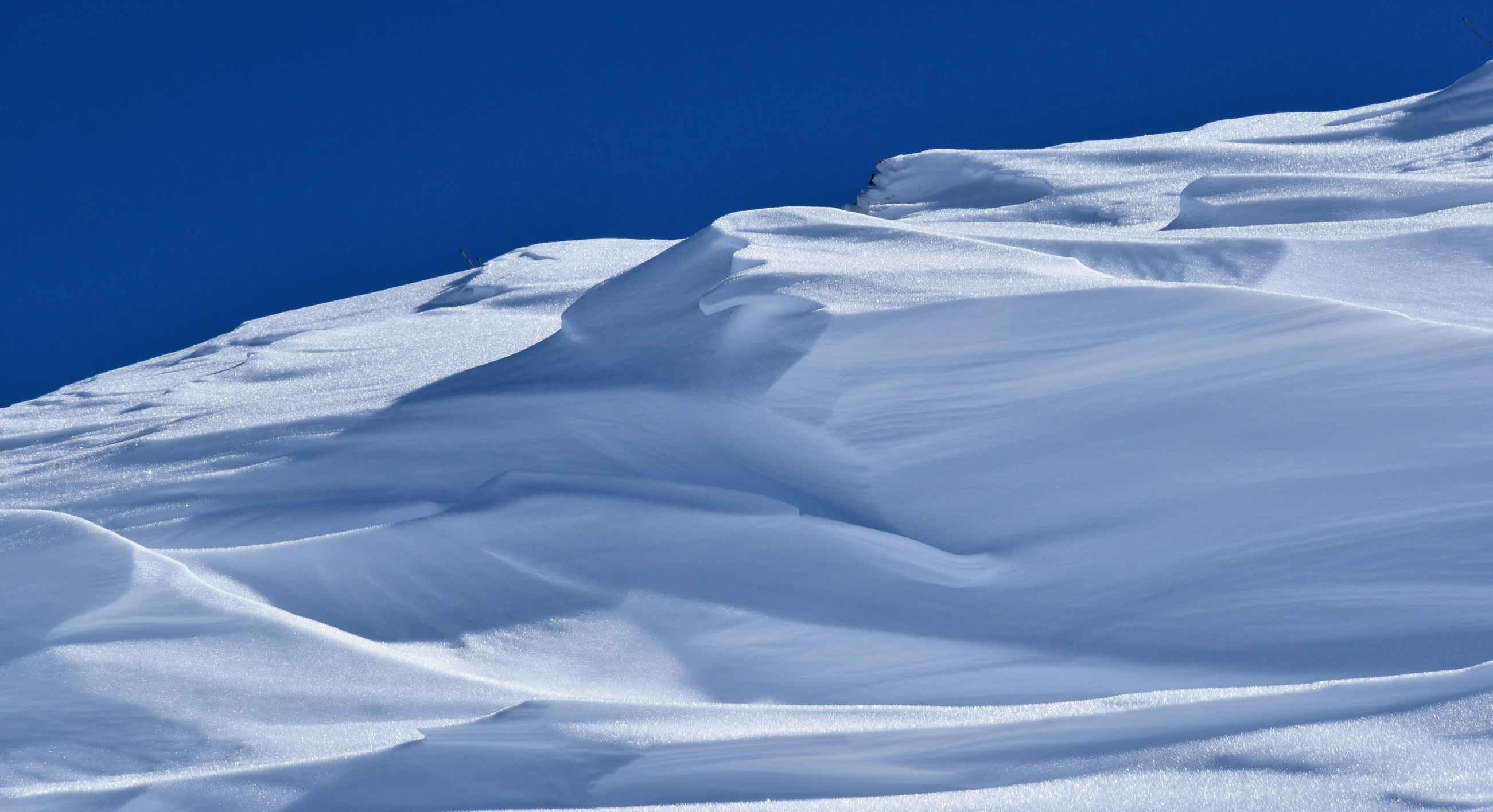 a skier is snowboarding down a steep snowy hill