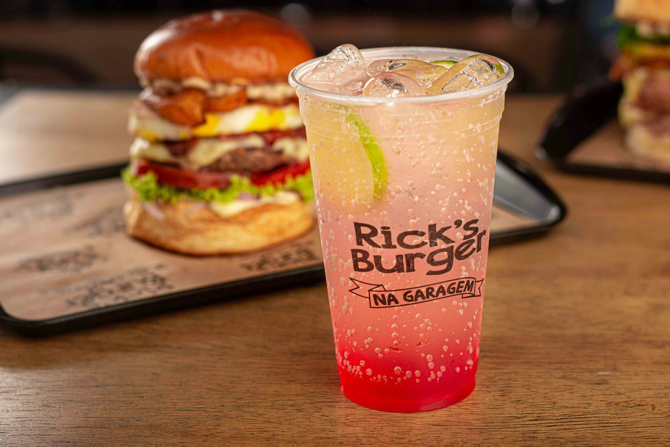 a pink drink with two hamburgers on the side