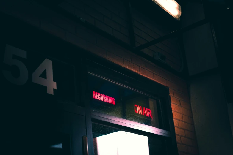 a brick building with a lit up door and the number 54 on it