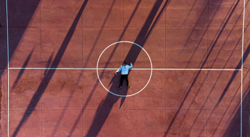 a man standing in the middle of an empty court