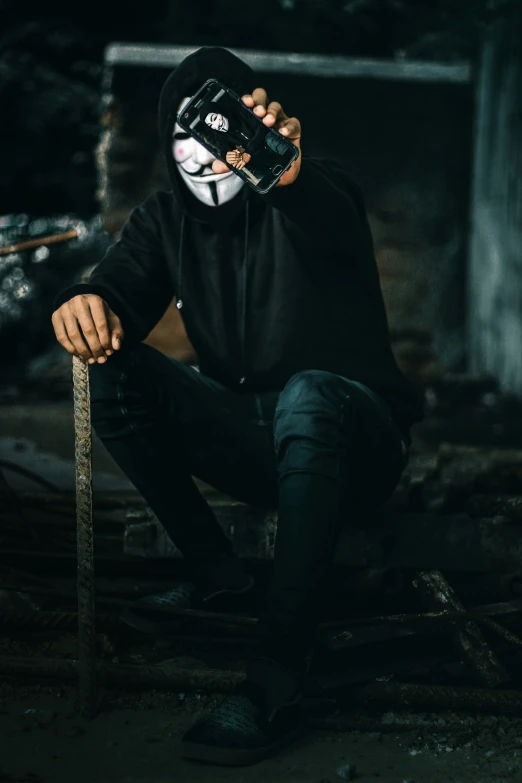a person in black hoodie and mask holding a knife