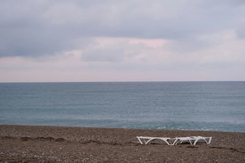 a bench sitting on a beach next to the ocean