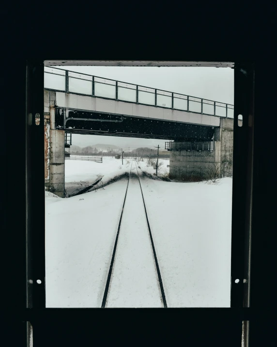 view from inside an old abandoned building showing railroad tracks