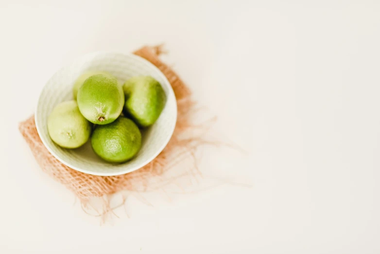 a small bowl containing several green fruit