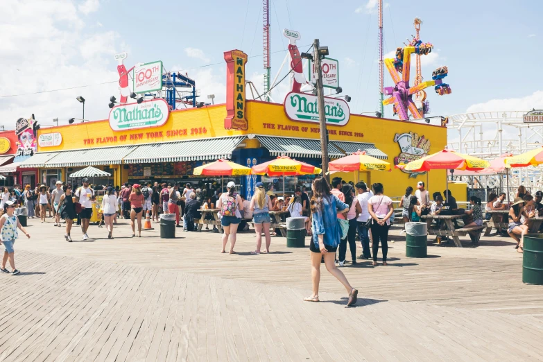 some people are walking around a carnival on the sidewalk