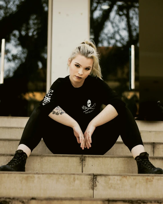 a woman sitting on steps in black boots