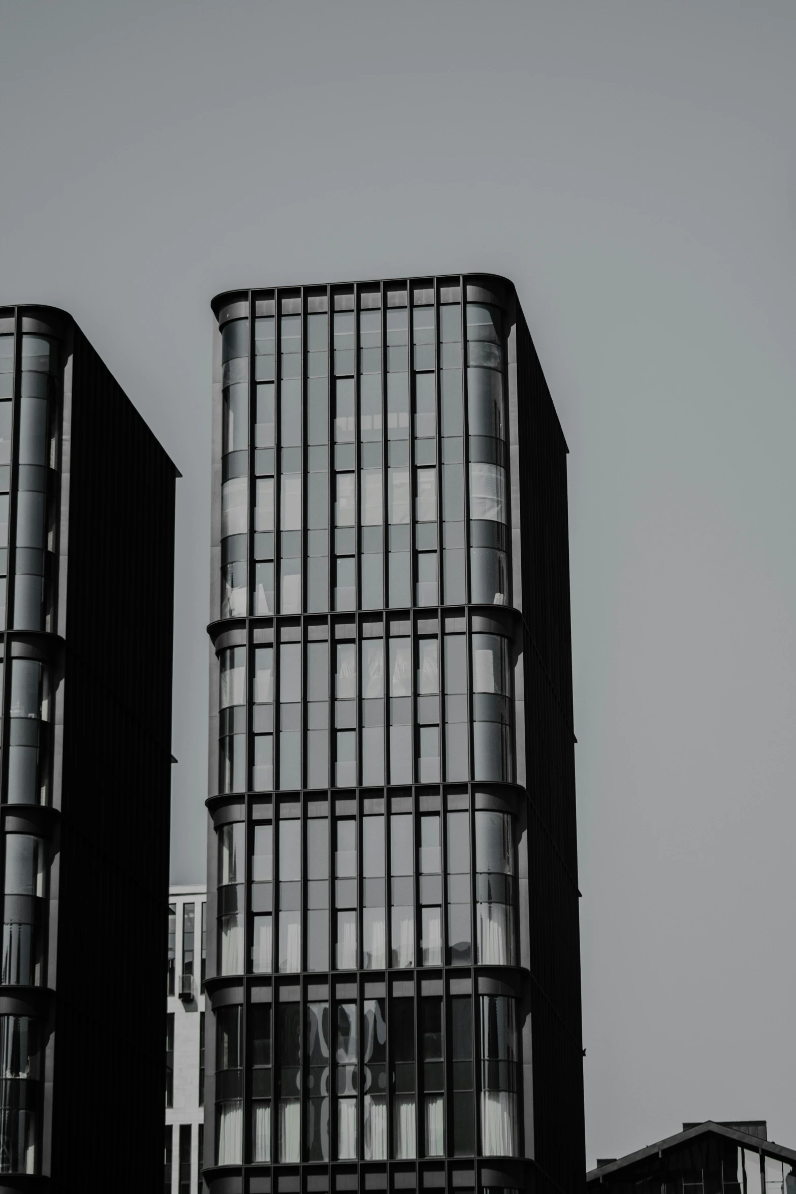 two tall buildings with large windows and bars on them