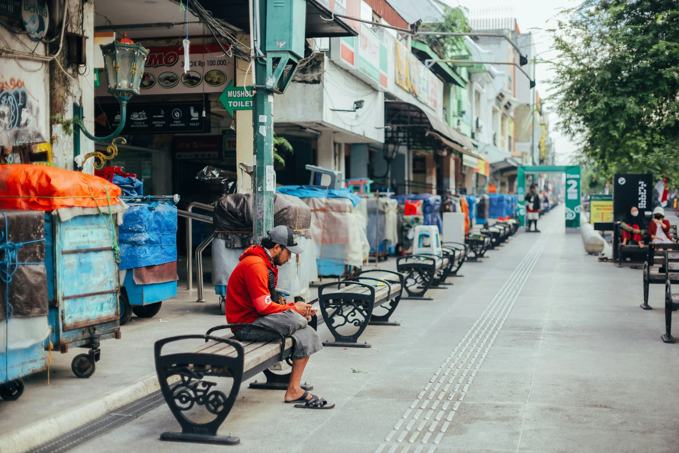 a person sitting on a bench near a bunch of buildings