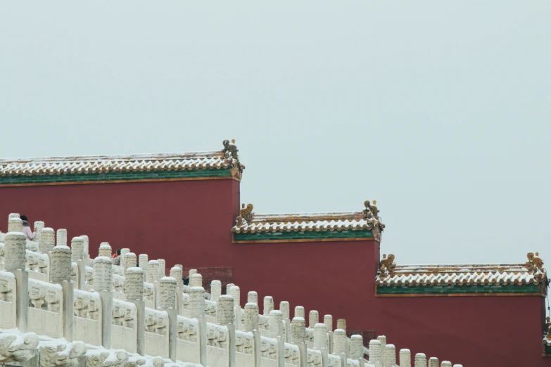 a large building with white chimneys and a few sculptures