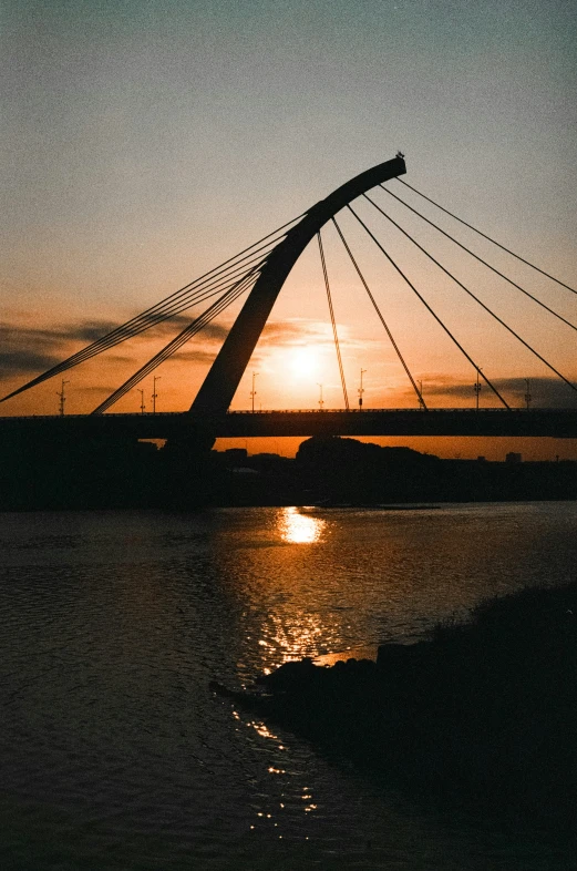 a sunrise with a view of a bridge