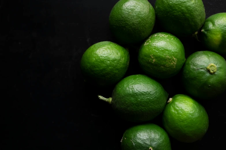 a group of green lemons sitting next to each other