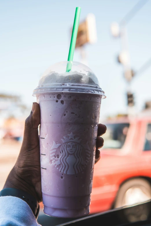 starbucks coffee in a purple cup being held by someone