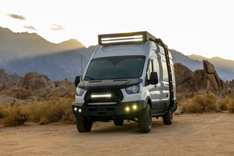 the van is parked in the desert with some mountains