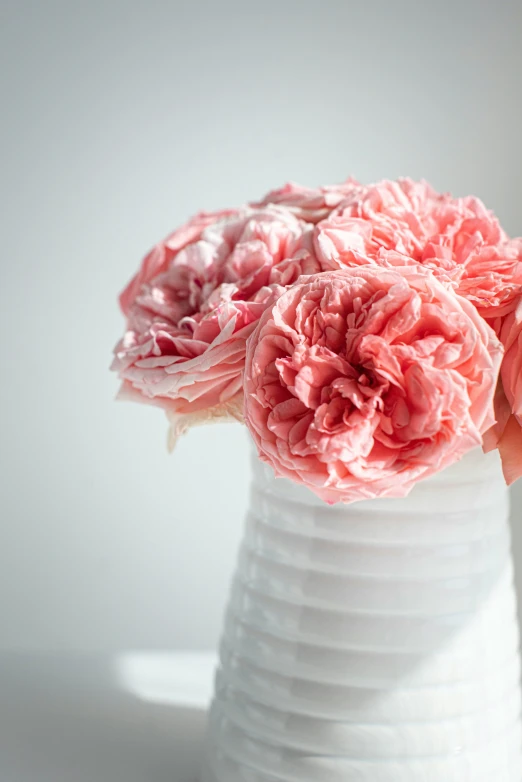 a bouquet of pink flowers sitting on top of a white vase