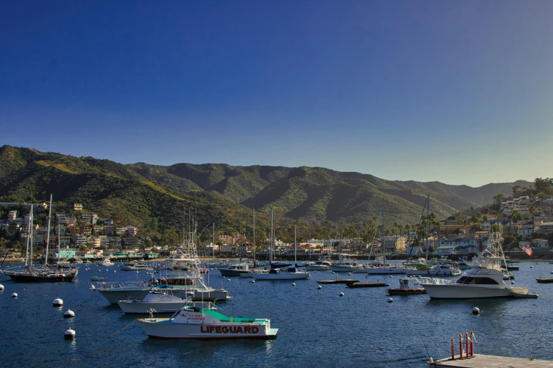 the sun is shining over boats in the water