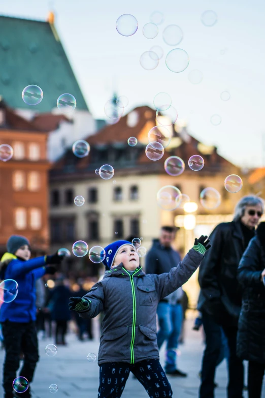 a  is standing on a sidewalk and playing with soap bubbles