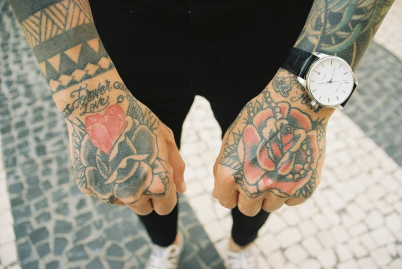 a man with tattoos and wearing black pants