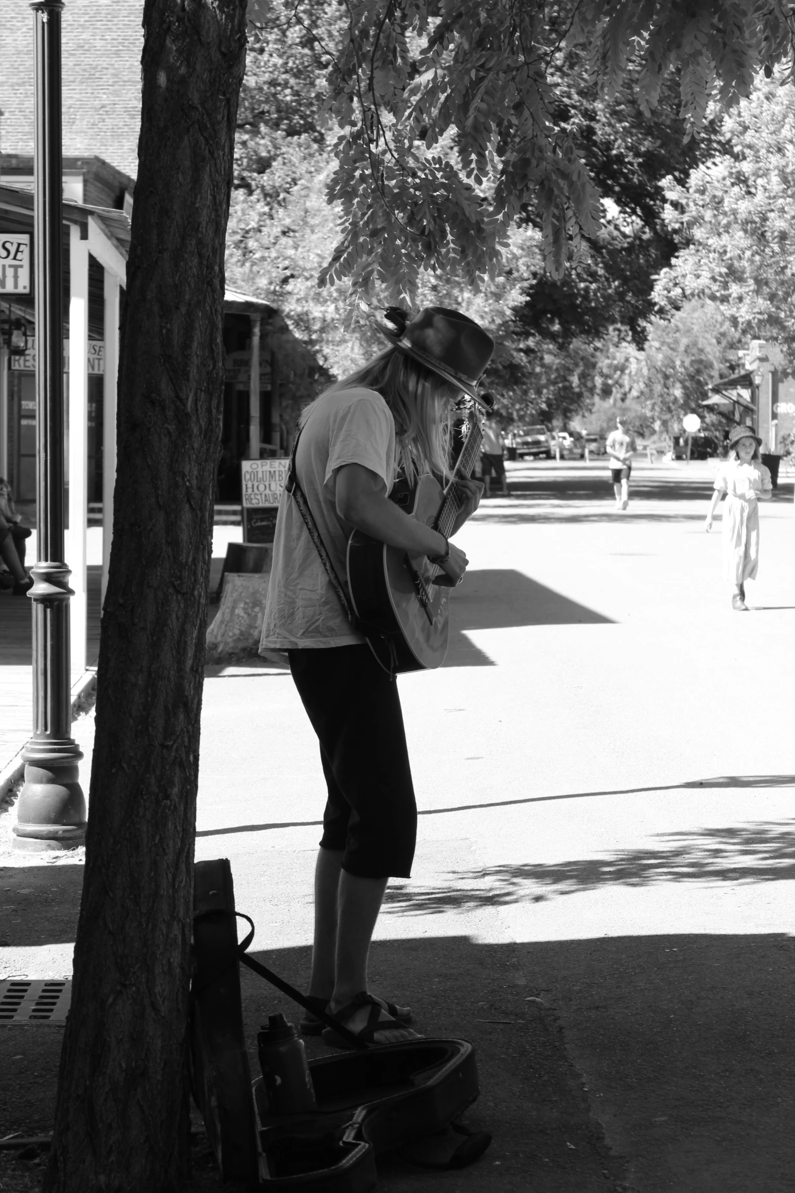 a person is playing on their guitar under a tree