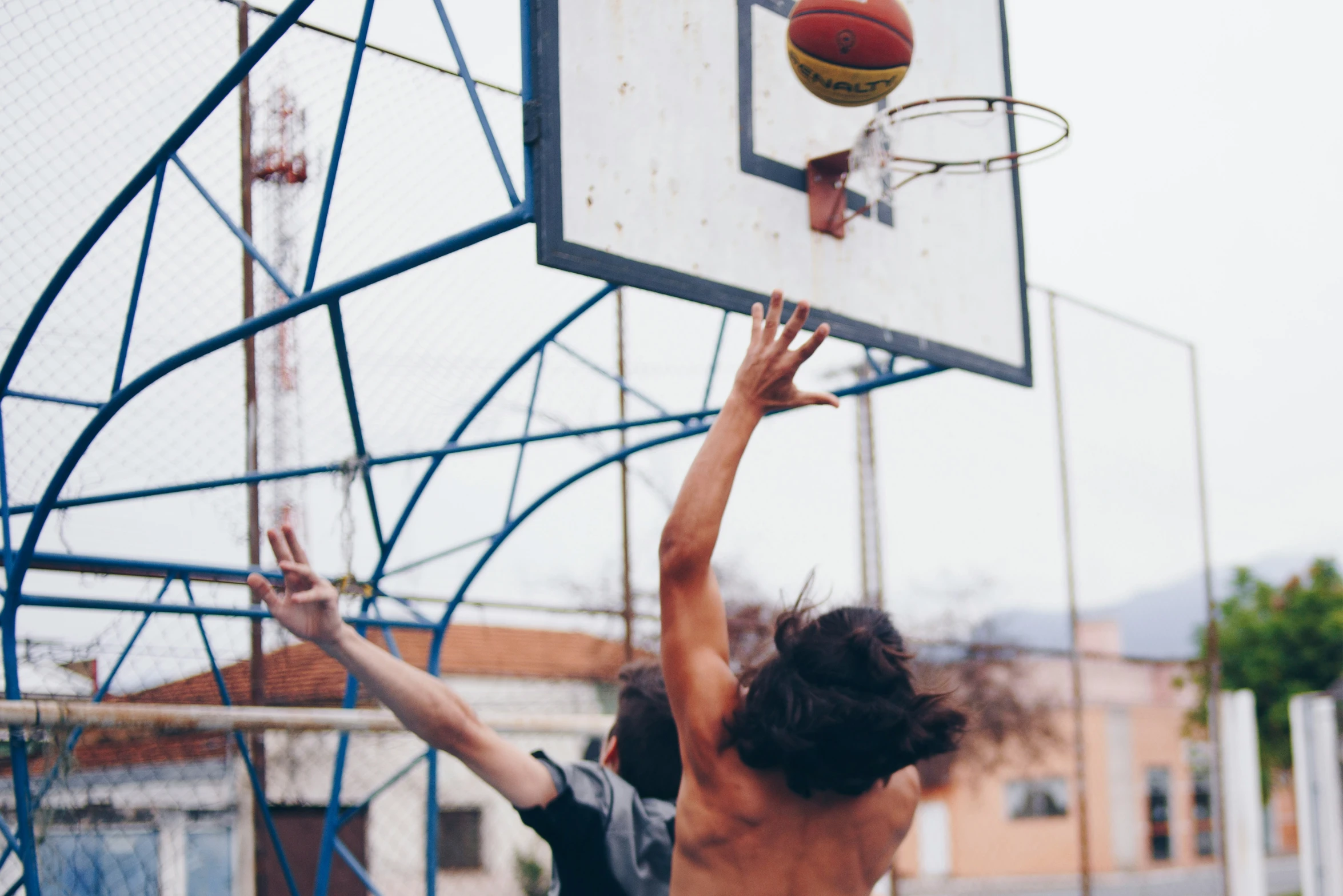 two guys are playing basketball and jumping to the basket