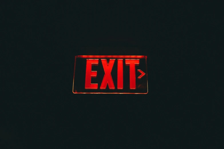 a red exit light on the side of a building