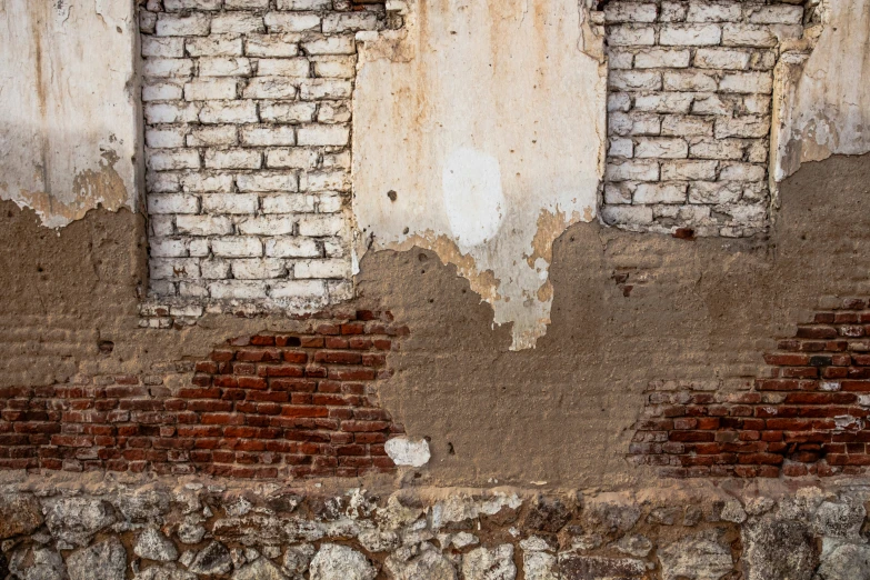 a clock on top of a brick wall next to a wall with s