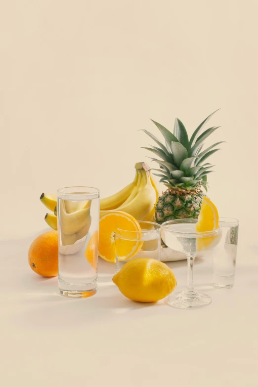 a pineapple and bananas next to glasses and fruit