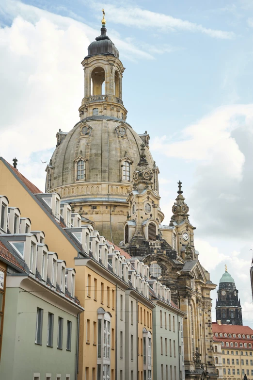 a very tall church spire next to many building