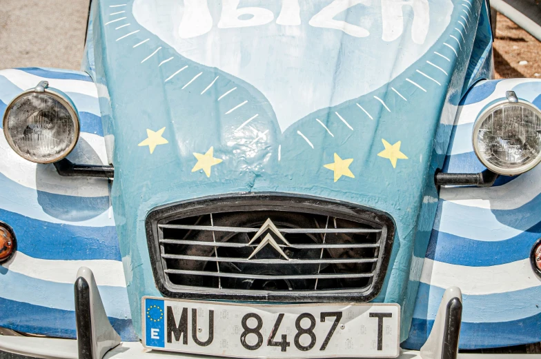 an old car covered in blue and yellow