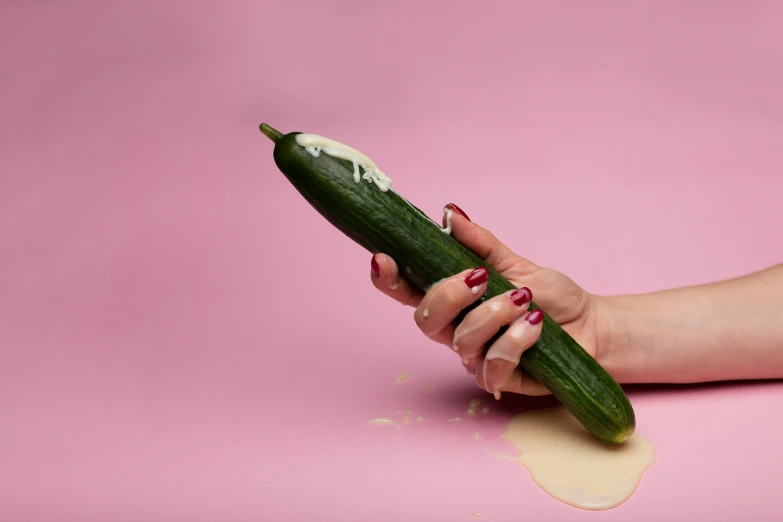 there is someone holding an old cucumber in their hand