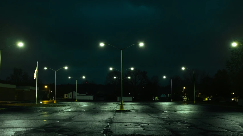 an empty parking lot surrounded by street lamps