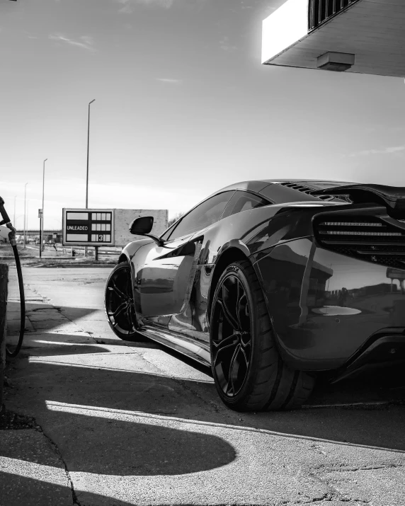 the man is putting gas into his sports car