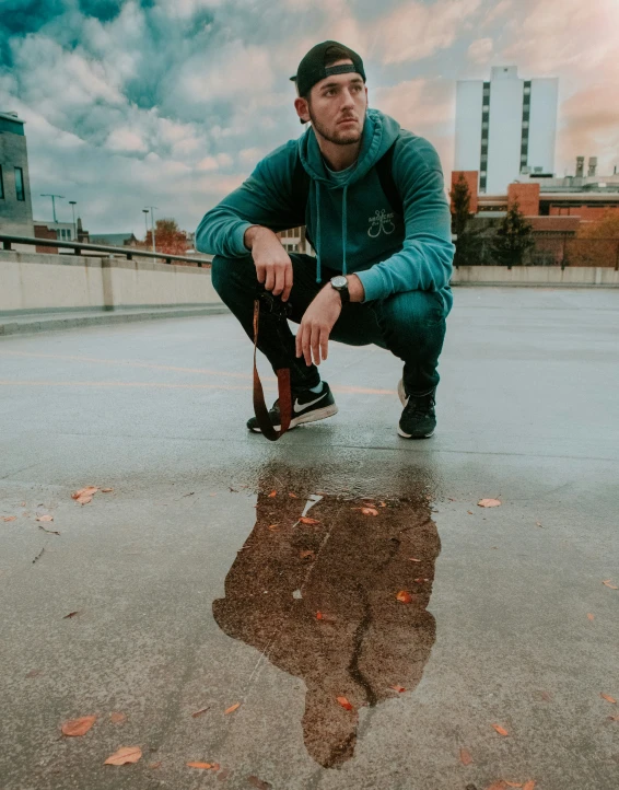 a man kneeling down while holding his skateboard