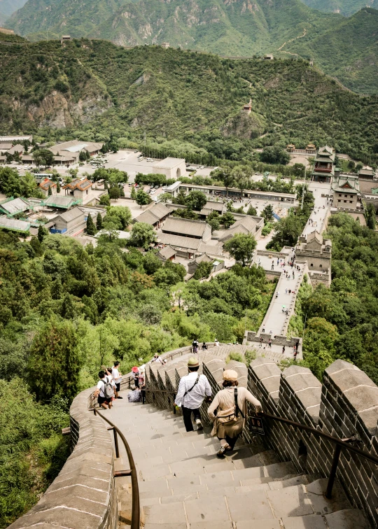 several people with their bags going up a stone wall