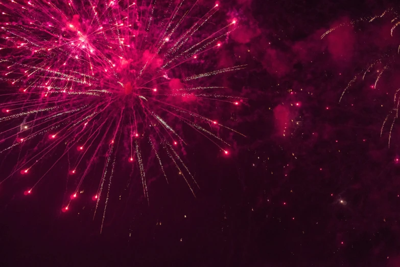 a bright red fireworks display on top of the night sky