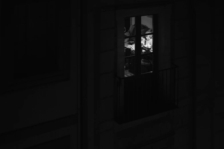 a man is looking out of the window at night