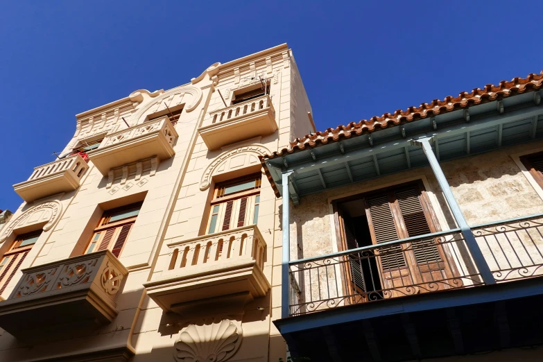 a tan building with balconies and balconyes is against a clear blue sky