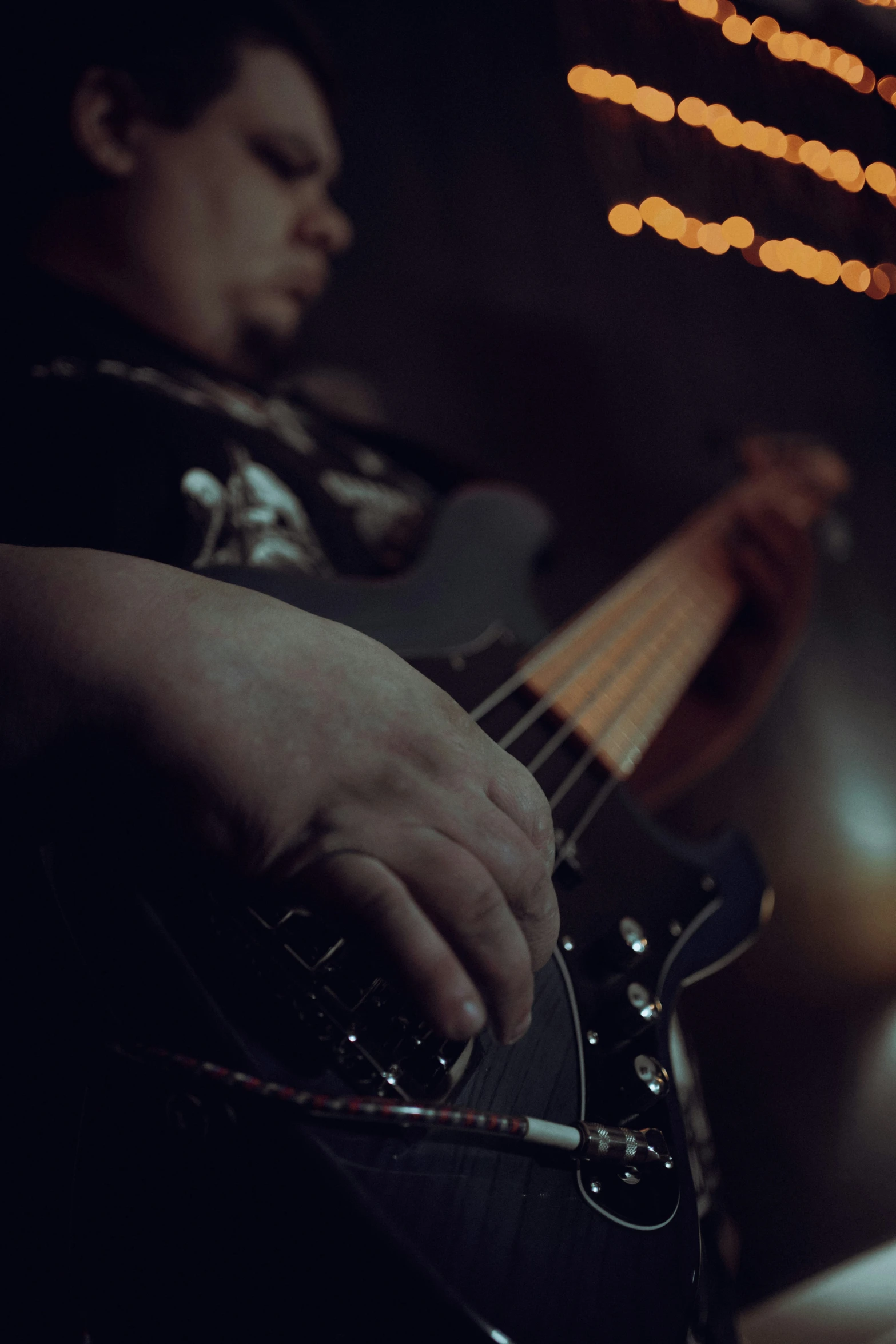 a man that is playing a guitar in the dark