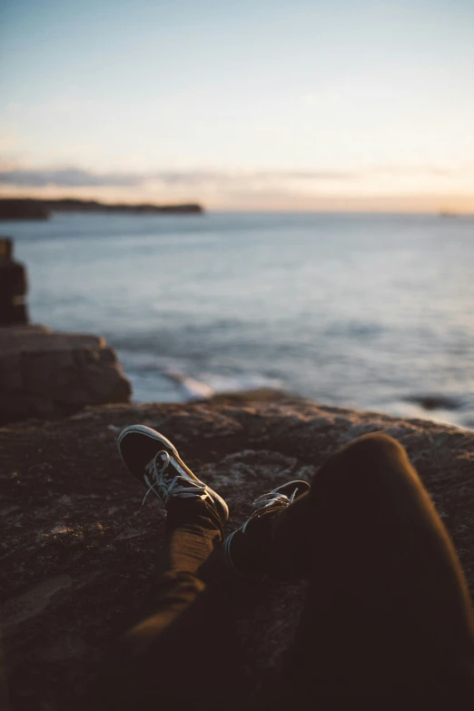 there is a person that is sitting at the edge of the pier